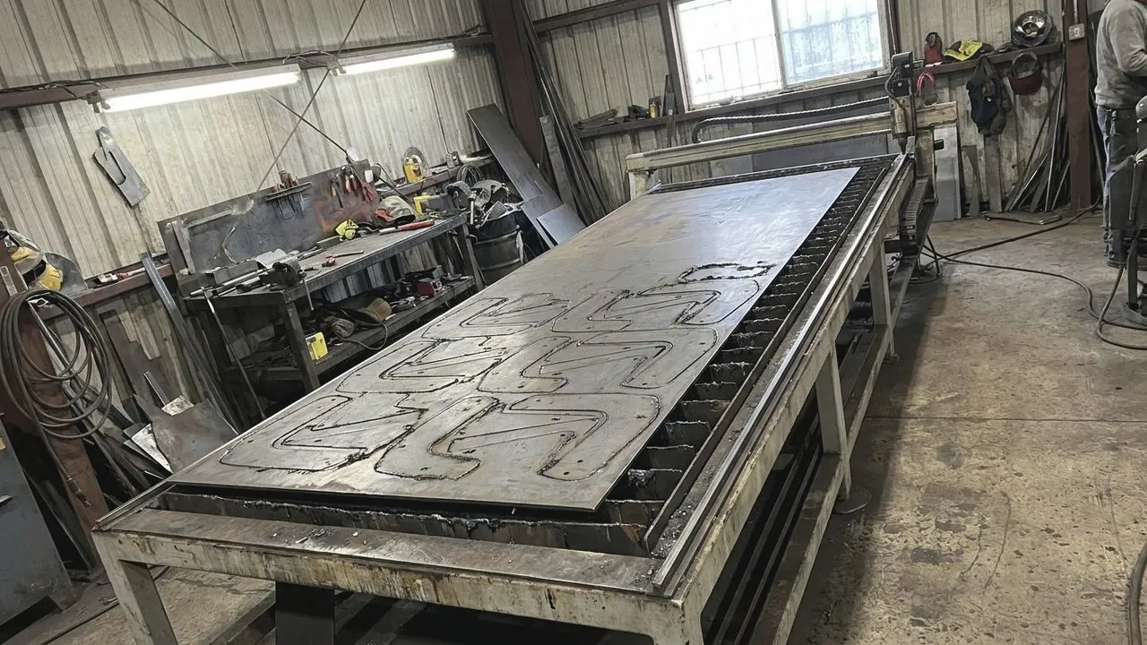 A CNC cutter slicing steel sheet.